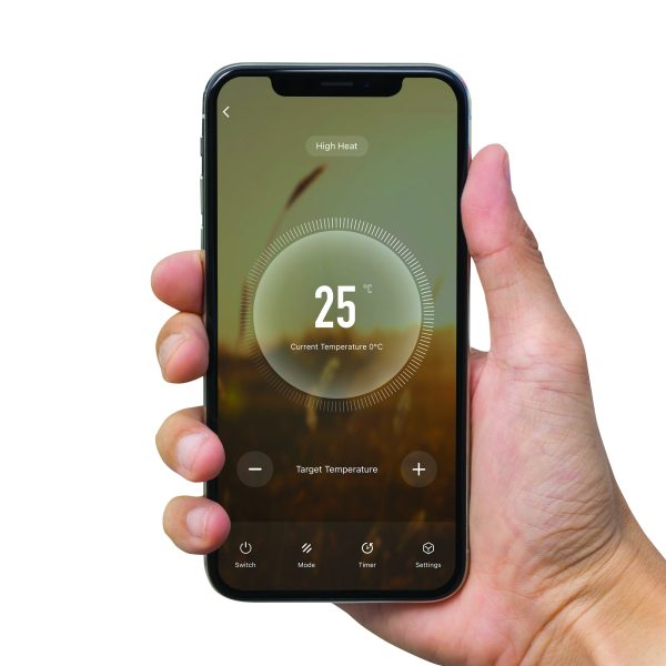 A hand holding a mobile phone with the an app that controls the free standing 9 fin oil radiator